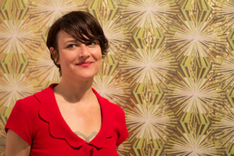 Designer and legend Jane Blevin in front of her Meteor Flower wallpaper at ICFF 2013