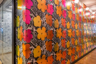 Warhol Flowers in Golden Shower brightens up any space including this hallway. You can see Brooklyn Toile in custom soft blue peeking out of the conference room as well.