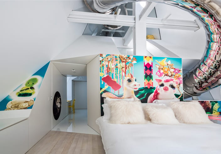 Everland prominently displayed in the guest bedroom of the the SkyHouse project by architect David Hotson and interior designer Ghislaine Viñas. It happens to be one of the most fun rooms in the home due to the large wrap of the stainless steel slide that cuts through the space and reflects the mural along its length.
