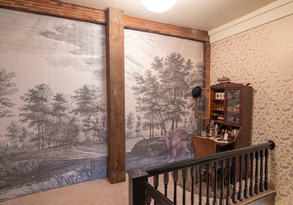 What's a landing area without a bar, playful patterned wallpaper and a custom mural of a giant historic etching that incorporates the family’s crest?!! Not a Flavor Paper production, that's for sure!