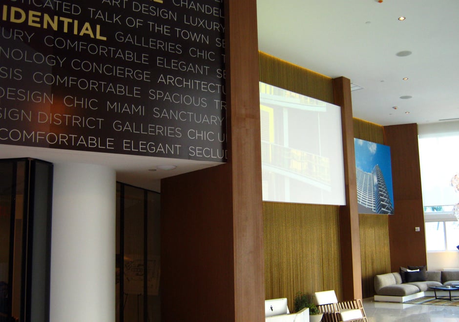 Dual wallpaper displays flank a projection screen in the sales office lobby