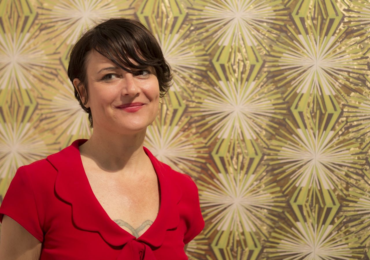 Designer and legend Jane Blevin in front of her Meteor Flower wallpaper at ICFF 2013