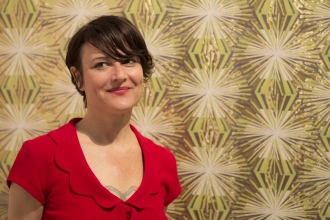 Designer and legend Jane Blevin in front of her Meteor Flower wallpaper at ICFF 2013